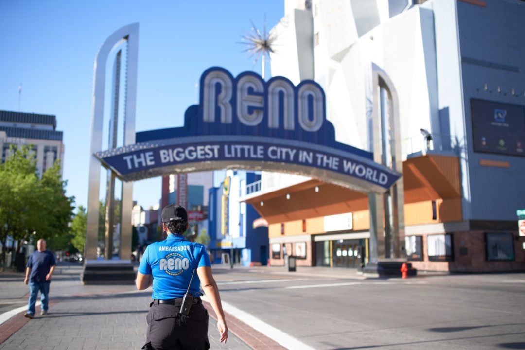 Downtown Reno ambassador walking underneath the Reno Arch.
