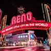 The Downtown Reno Arch lit up in red lights at night.