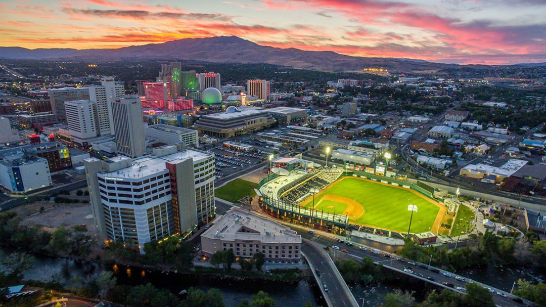 Aeriel view of Downtown Reno with the Greater Nevada Field lit up for a game.