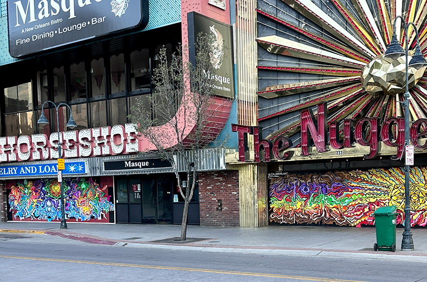 Murals painted under the sign, "The Nugget" and under "The Horseshoe" sign with red, orange, yellow, green, blue, and purple abstract shapes and lines.