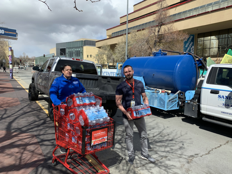 Ambassadors pushing a grocery cart of water bottles during the Downtown Clean Up